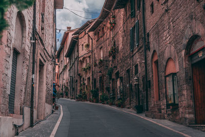 Empty road amidst buildings in city