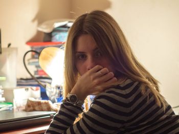Portrait of young woman sitting at table