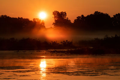 Scenic view of lake against orange sky