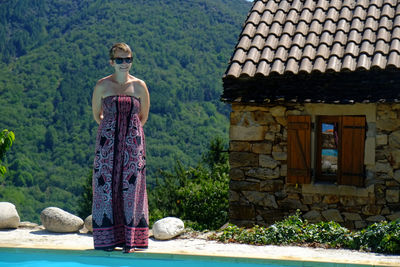 Low angle view of young woman standing against building