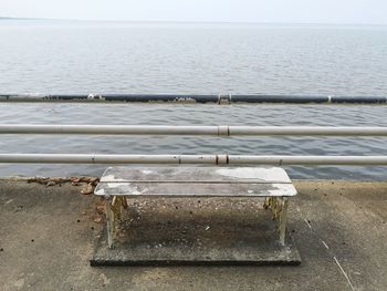 Close-up of railing by sea against sky
