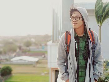 Man in hooded shirt standing in city