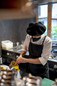 Chef pouring batter while standing in restaurant kitchen