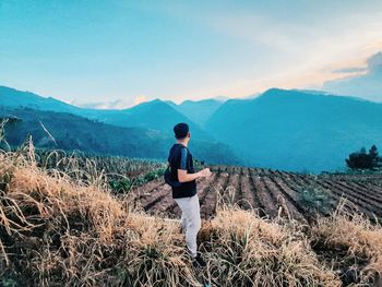 Man looking at mountains against sky