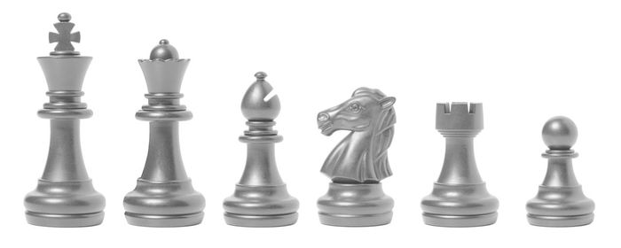 Low angle view of chess pieces against white background