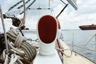 Close-up of sailboats moored in sea against sky