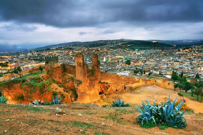 View of cityscape against cloudy sky
