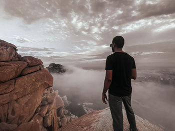 Rear view of man standing on rock