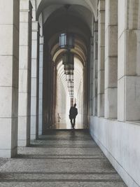 Rear view of man walking in corridor of building