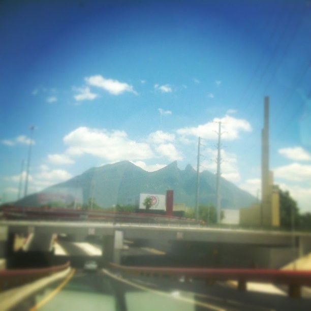 transportation, sky, road, mountain, blue, mode of transport, car, connection, land vehicle, bridge - man made structure, railing, highway, built structure, road marking, architecture, cloud, travel, on the move, cloud - sky, street