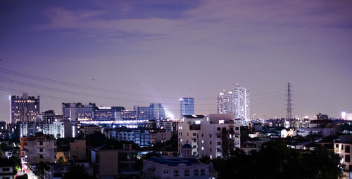 High angle view of illuminated buildings against sky at night