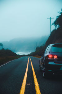 Cars on road against sky in city