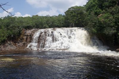 Scenic view of waterfall against sky