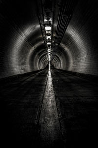 Empty road in illuminated tunnel