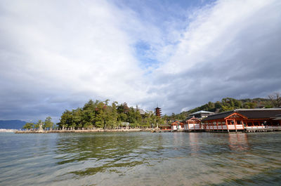 Itsukushima shrine by sea against sky