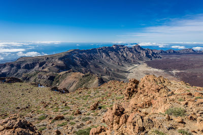 Scenic view of mountains against blue sky