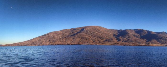 Scenic view of calm sea against clear blue sky