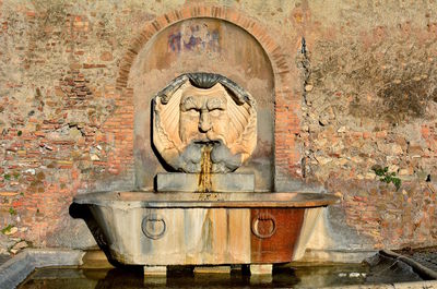 Statue of fountain against wall