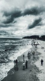 People standing on beach against sky