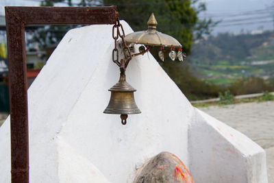 Close-up of electric lamp hanging outside temple