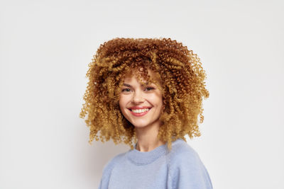 Portrait of smiling young woman against white background