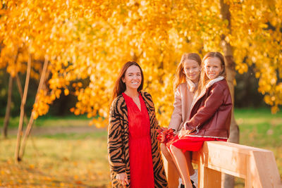 Portrait of a smiling young woman in autumn leaves