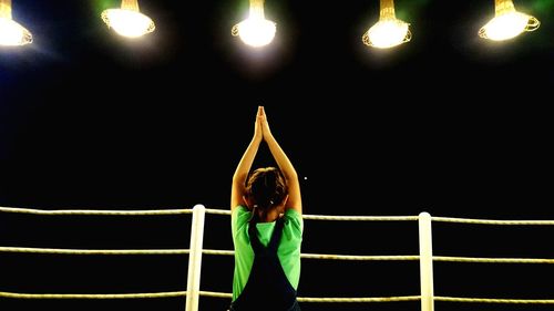 Full length of woman standing against black background