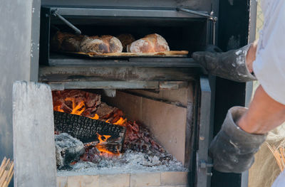 Midsection of man on barbecue grill