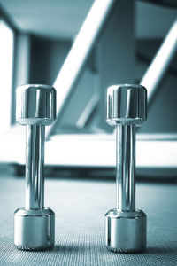 Close-up of dumbbells on floor at gym