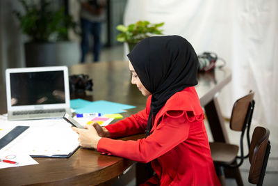 Side view of woman working on table