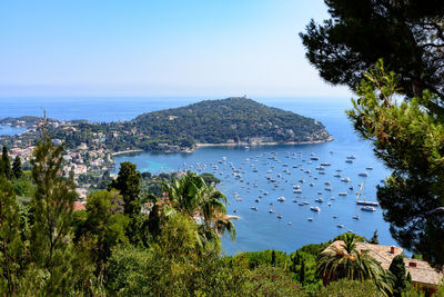 Boats moored in sea against clear sky