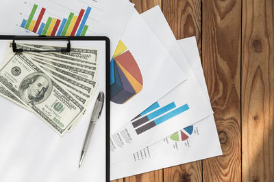 High angle view of documents with money on table