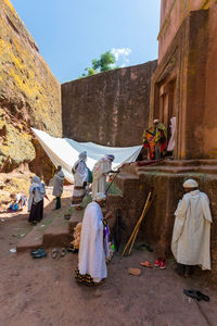 Rear view of people in traditional building against sky