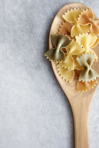 Close-up of farfalle in wooden spoon on marble