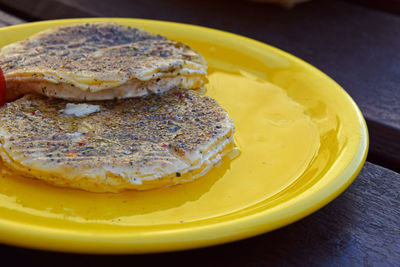 Pancakes in yellow plate on table