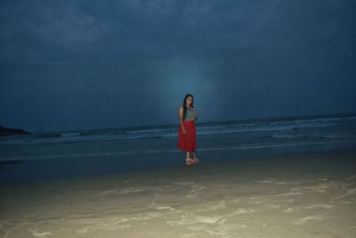 Woman standing on beach against sky