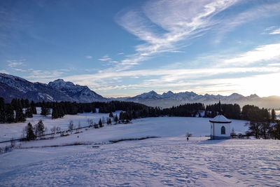 Scenic view of snow covered mountains against blue sky