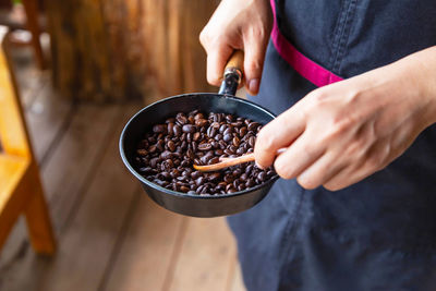 Midsection of man holding coffee cup