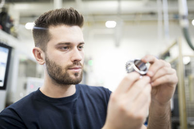 Man examining workpiece in a factory