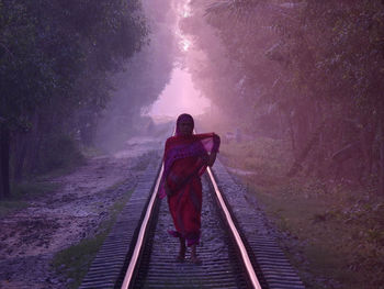 Woman standing on railroad track
