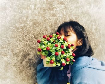 Portrait of woman holding red flowers