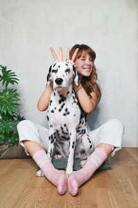 Portrait of teenage girl sitting on hardwood floor at home