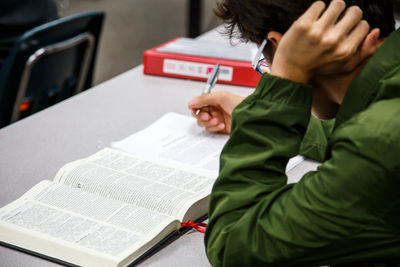 Midsection of man reading book on table