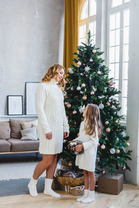 Full length of woman with christmas tree