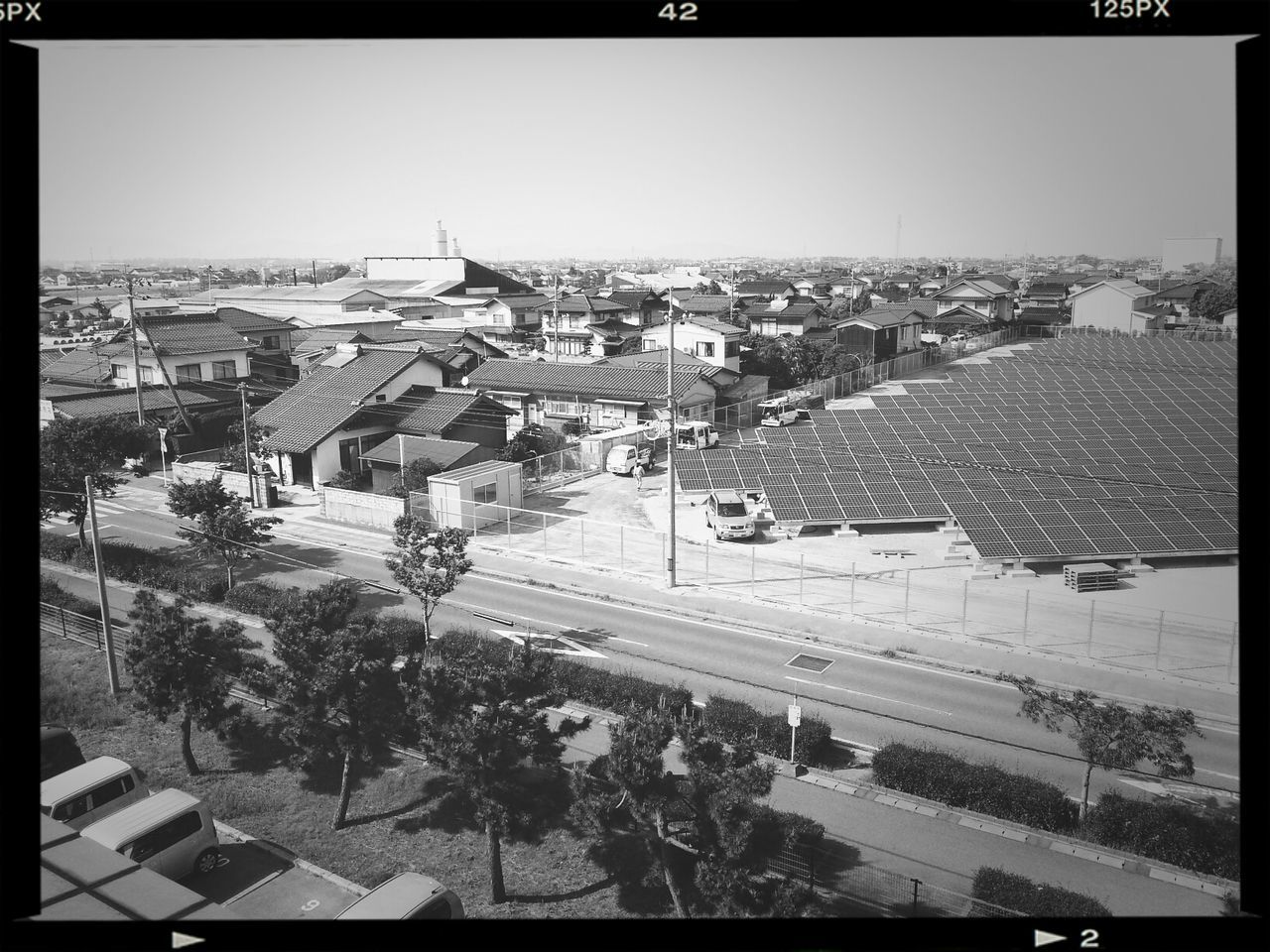 transfer print, building exterior, high angle view, city, architecture, built structure, auto post production filter, cityscape, clear sky, transportation, crowded, city life, street, road, large group of people, car, residential district, copy space, sky, elevated view