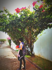 Rear view of woman walking on footpath by road