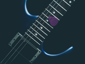 Close-up of guitar against black background