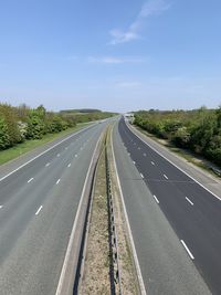 View of empty highway against blue sky