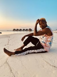 Side view of woman sitting on beach