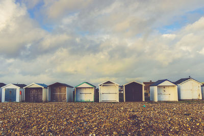 Beach huts against cloudy sky